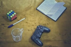 Rubik's cube, notebook, and game controller on a textured surface