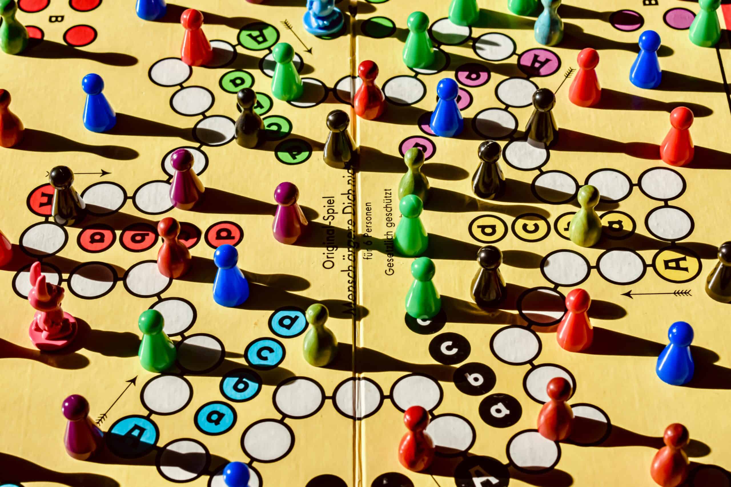 Colorful game pieces on a board game, including pawns and circular markers.